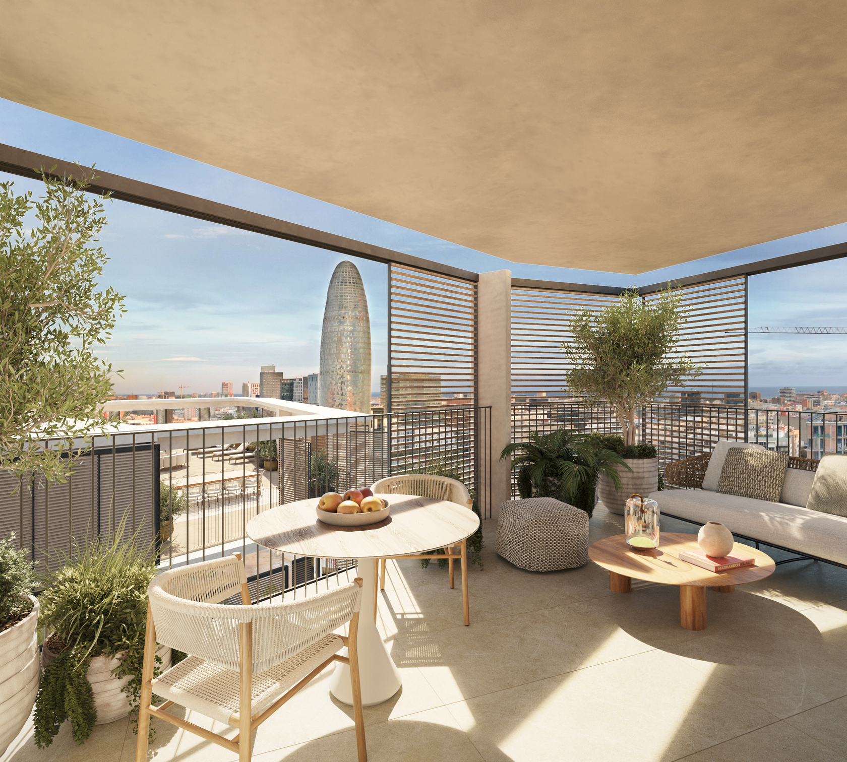 Private terrace with a round dining table, a lounge sofa, olive trees and wooden slat screens, framing the Torre Glòries and the city skyline.